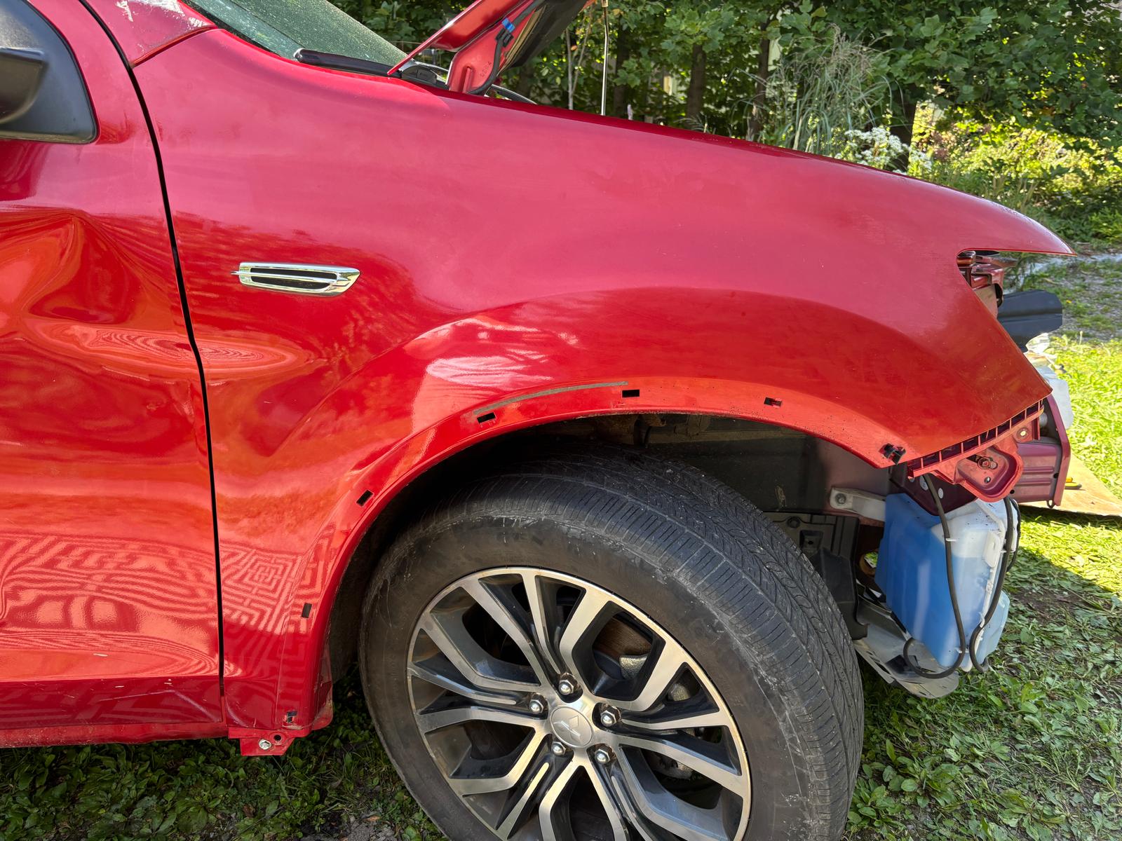 Replacement red front fender fitted to the Mitsubishi Outlander during reassembly